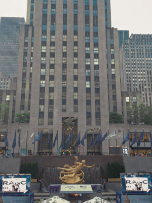 The statue of liberty is seen.
(architecture, city, building, travel, skyline, downtown, outdoors, cityscape, skyscraper, business, no person, urban, street, water, office, finance, daylight, sky, landscape, bridge)